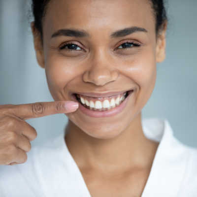 Woman pointing to her smile