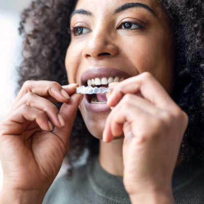 Woman putting in her Invisalign clear aligners